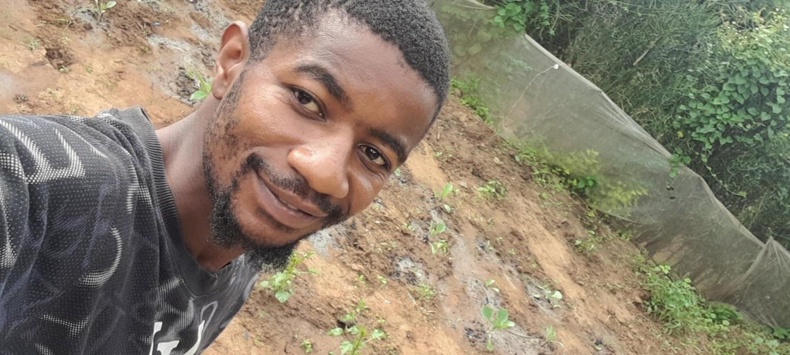 A YRUD member tending young seedlings in a shaded nursery