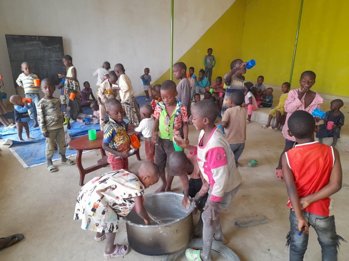 Children seated together sharing a meal in a community hall