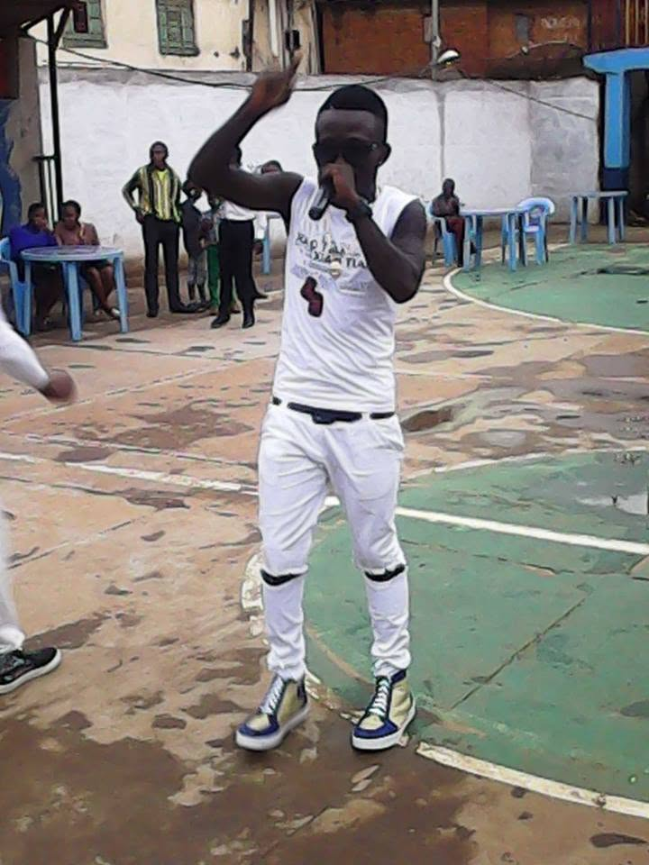 Eltou performing with a microphone on an outdoor court