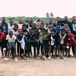 The whole club standing together on a dirt pitch, a second group photo