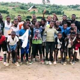 The boys of the club gathered together on the pitch, some with arms raised